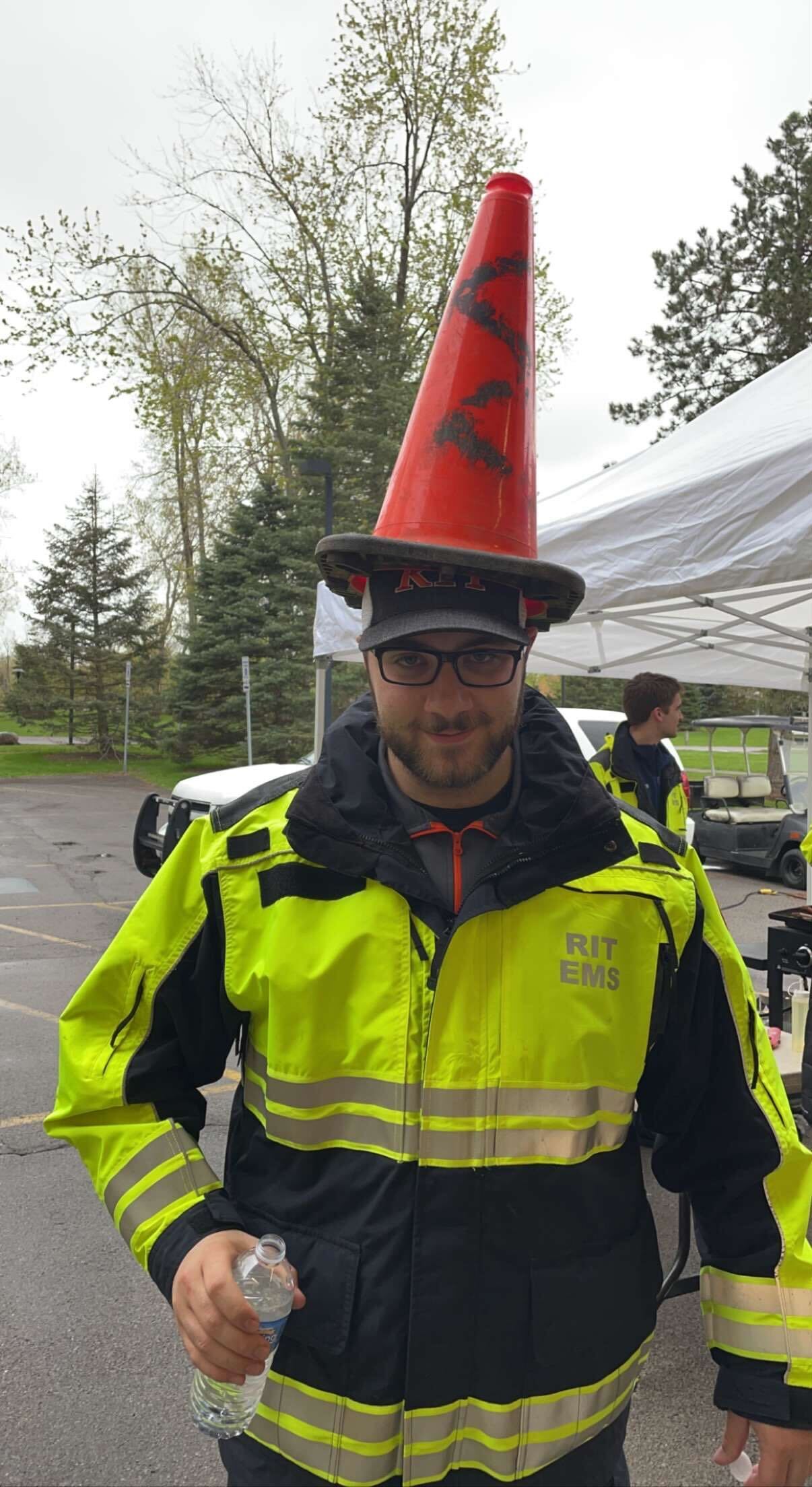 Aidan in a high-vis jacket with a cone on his head